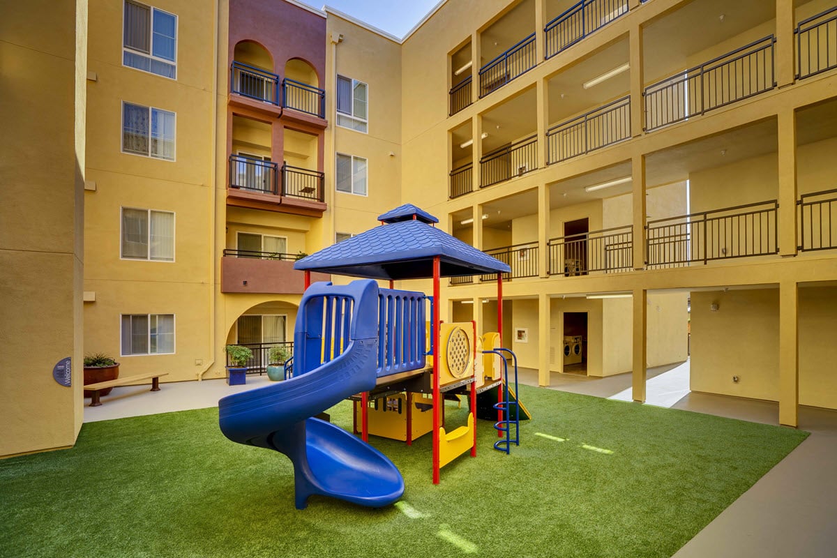 Play area at Mayfair Court featuring a climbing structure and slide